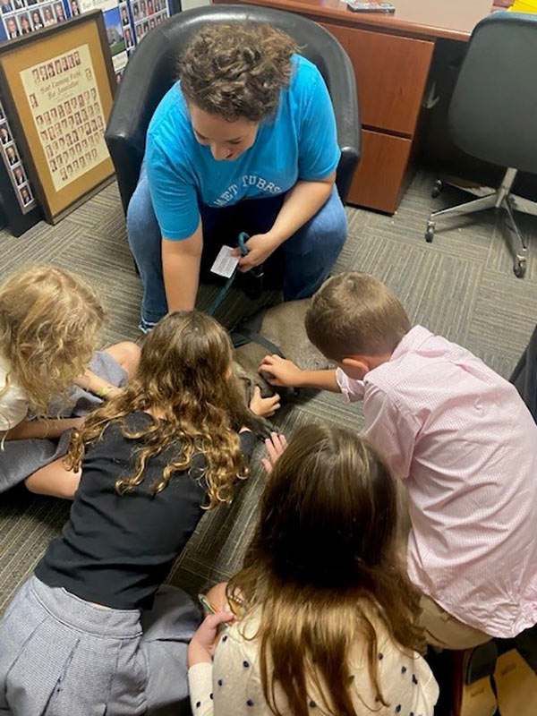 You may not be able to see that happy dog getting lots of belly rubs, but we promise Tubbs is under all those loving hands and having a doggone good time!  Thank you to Tubbs and Amber Sheppard for providing the pawsitively best finale ever to “Bring Your Kid To Court Day”.